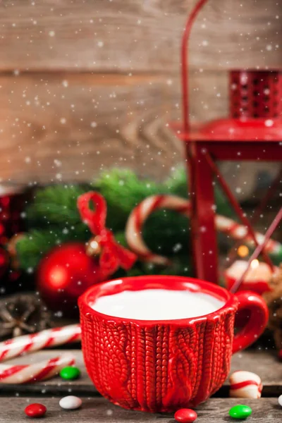 Christmas time red cup of milk and latern with candle light — Stock Photo, Image
