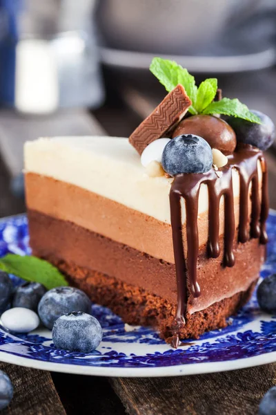 Stuk van heerlijke chocolademousse taart gedecoreerd met verse bl — Stockfoto