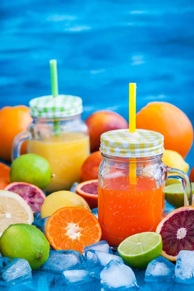 Sumo de vitamina cítrica com frutas frescas ao redor — Fotografia de Stock