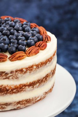 Çıplak havuçlu kek dekore edilmiş taze yaban mersini ve pekan