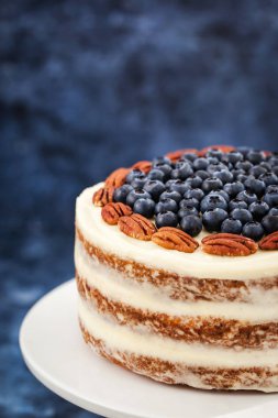 Çıplak havuçlu kek dekore edilmiş taze yaban mersini ve pekan