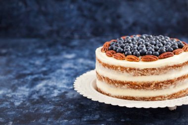 Çıplak havuçlu kek dekore edilmiş taze yaban mersini ve pekan