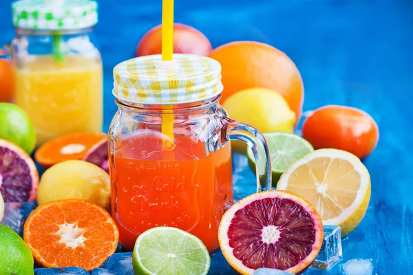 Citrus vitamin juice with fresh fruits around — Stock Photo, Image