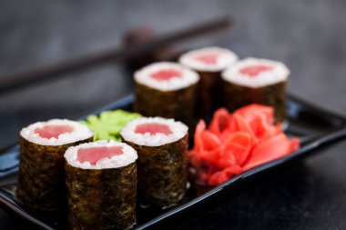 Lezzetli taze orkinos maki sushi koyu arka plan üzerinde rulo