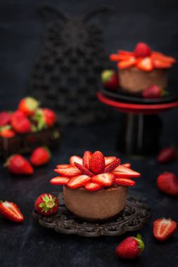 Mini çikolata cheesecake tatlı taze strawber ile dekore edilmiştir.