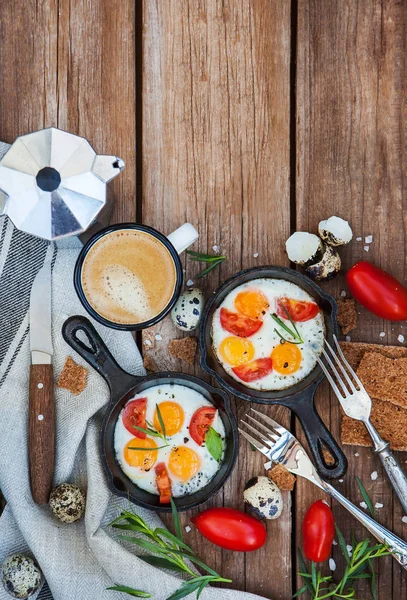 Fried eggs with tomatoes in frying pans — Stock Photo, Image
