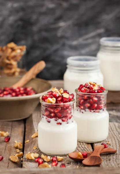 Yogur fresco con semillas de granada y nuez en frascos de vidrio — Foto de Stock