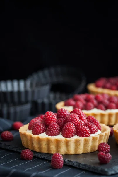 Delicious raspberry mini tarts on dark background — Stock Photo, Image