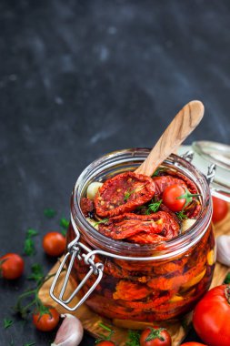 Kurutulmuş domates sarımsak ve bir kavanoz zeytin yağı ile