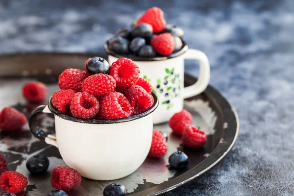 Fresh ripe blueberry and raspberry in mugs — Stock Photo, Image