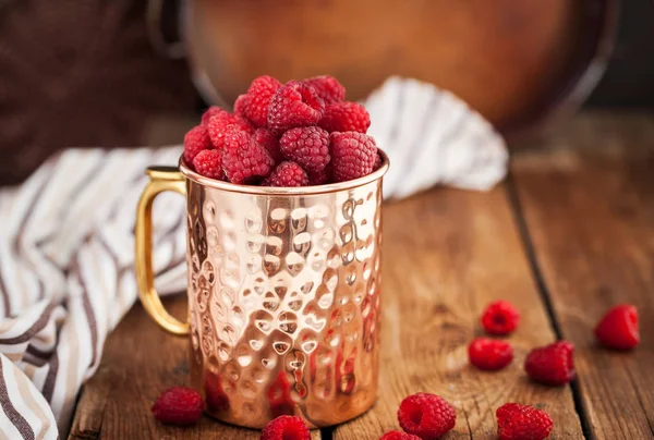 Frambuesas frescas maduras en una taza de cobre — Foto de Stock