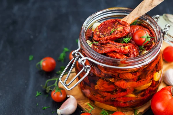 Sun dried tomatoes with garlic and olive oil in a jar — Stock Photo, Image