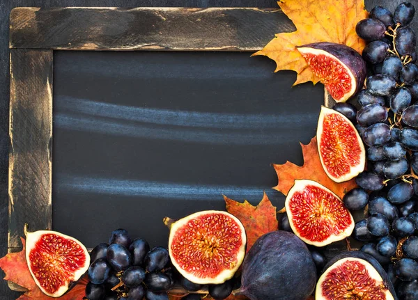 Autumn frame with chalk board, leaves, figs and grape,  space fo