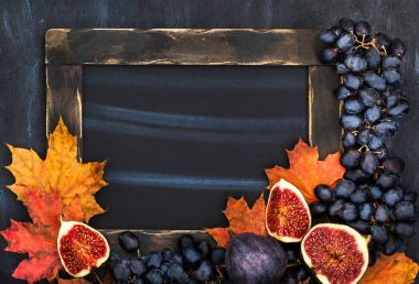 Tebeşir tahtası, yaprakları, incir ve üzüm, sonbahar çerçeve alanı fo