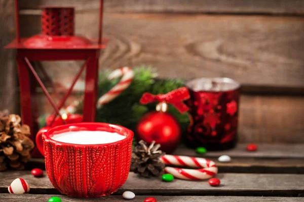 Navidad taza roja de leche y latern con luz de vela, hol —  Fotos de Stock