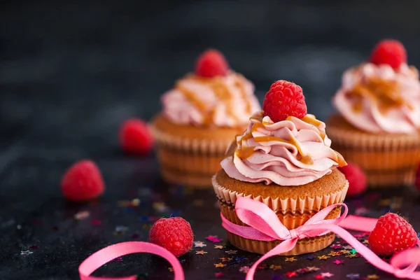 Raspberry and caramel cupcakes on dark background — Stock Photo, Image