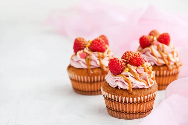 Raspberry and caramel cupcakes on white background — Stock Photo, Image