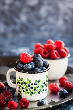 Olgun taze yaban mersini ve kupalar içinde ahududu 