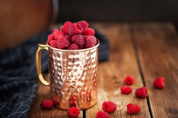 Frambuesas frescas maduras en una taza de cobre — Foto de Stock