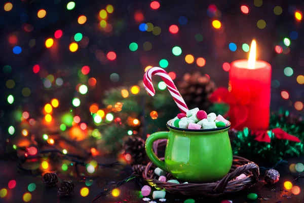 Green mug of hot chocolate with marshmallows and candy cane on h — Stock Photo, Image