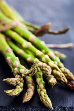 Koyu arka plan üzerinde ham taze kuşkonmaz yakın çekim