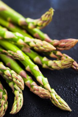 Koyu arka plan üzerinde ham taze kuşkonmaz yakın çekim