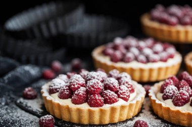 Koyu arka plan üzerinde lezzetli ahududu mini turta