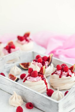 Lezzetli mini Pavlova beze pasta taze raspbe ile dekore edilmiştir.