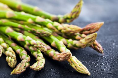 Koyu arka plan üzerinde ham taze kuşkonmaz yakın çekim