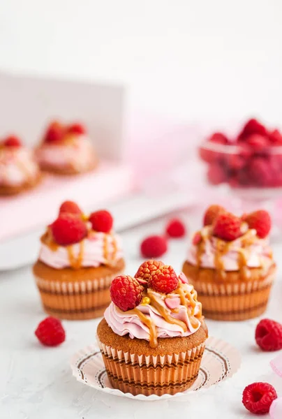 Hallon- och kolasås cupcakes på vit bakgrund — Stockfoto