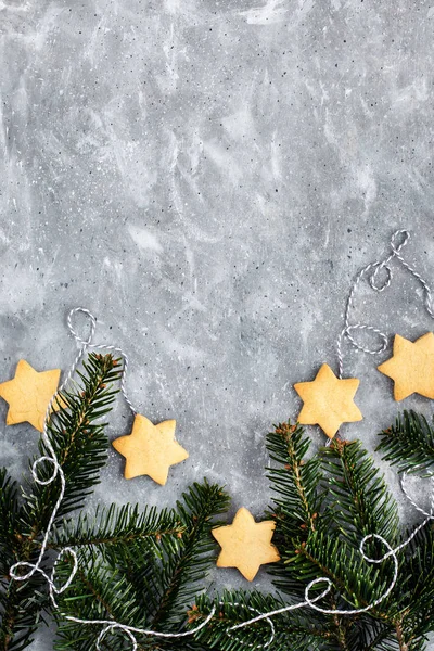 Chrismtas cookie stars and fir tree branches on gray background, — Stockfoto