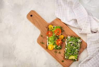 Avocado rye toasts with green herbs, onion and cherry tomatoes, 