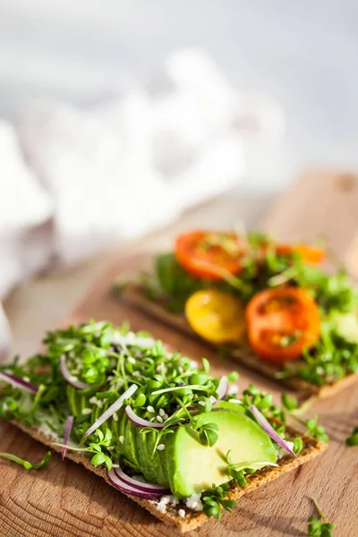 Avocado rye toasts with green herbs, onion and cherry tomatoes, — Stock Photo, Image