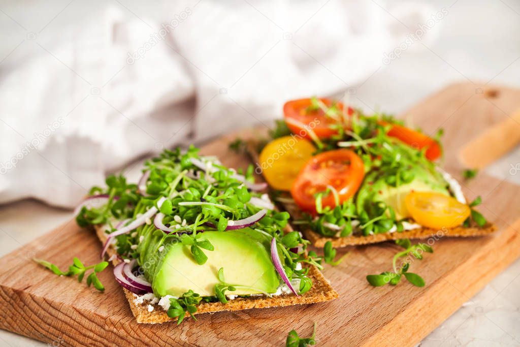 Avocado rye toasts with green herbs, onion and cherry tomatoes, 