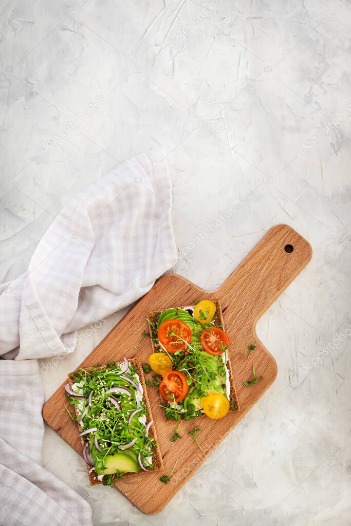 Avocado rye toasts with green herbs, onion and cherry tomatoes, 