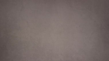 Topları, kartı ve hediyeleri olan kırmızı Noel süslemesi gri arka planda görünür. 