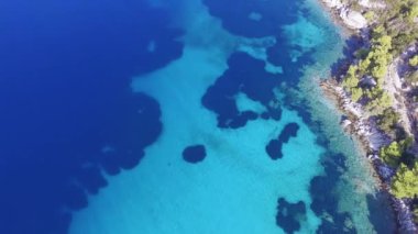 Mavi ve turkuaz kristal berrak deniz kıyısında güzel bir sahilin insansız hava aracı görüntüleri.