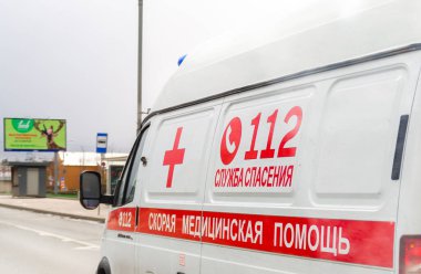 Moskova, Rusya - 19 Nisan 2020: Coronavirus küresel salgını, şehir yolunda Rus ambulans aracına yakın çekim. Yan görüş. Bir arabaya yazı, çeviri: ambulans, 112 Kurtarma Servisi