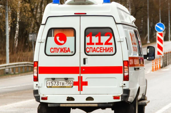 Moskova, Rusya - 19 Nisan 2020: Coronavirus küresel salgını, yolda ilerleyen Rus ambulans aracı. Bir arabaya yazı, çeviri: 112 Kurtarma Servisi