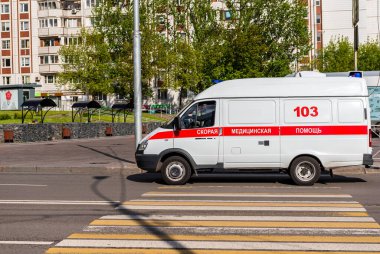 Moskova, Rusya - 22 Mayıs 2020: Coronavirus küresel pandemik iyileşme, Rus ambulans arabası şehir yolunda, yaya geçidinde. Yan görüş. Bir arabaya yazı, çeviri: ambulans, 103