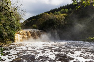 İngiltere 'nin Northumberland ve Cumbria eyaletlerinin sınırındaki Irthing Vadisi' ndeki Crammel Linn şelalesinde akan hızlı akarsu..