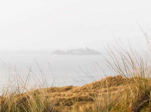 コピースペースとの距離にある専用灯台のある英国砂丘の野生の草 — ストック写真