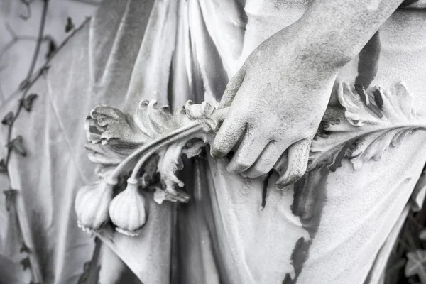 Hand with flowers, close up of an old sculpture — Stock Photo, Image