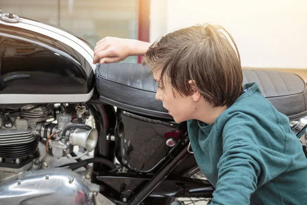 10 代の少年がバイクを調べます — ストック写真