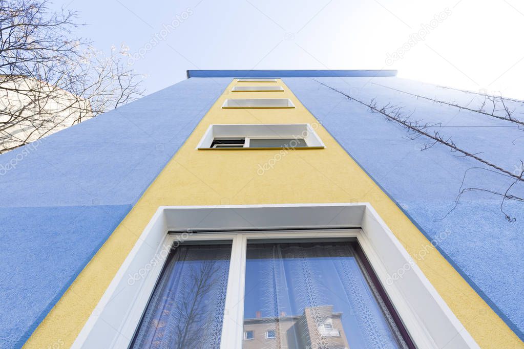 blue and yellow facade of an apartment house