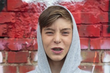 kızgın genç çocuk destek ve kırmızı duvar ile