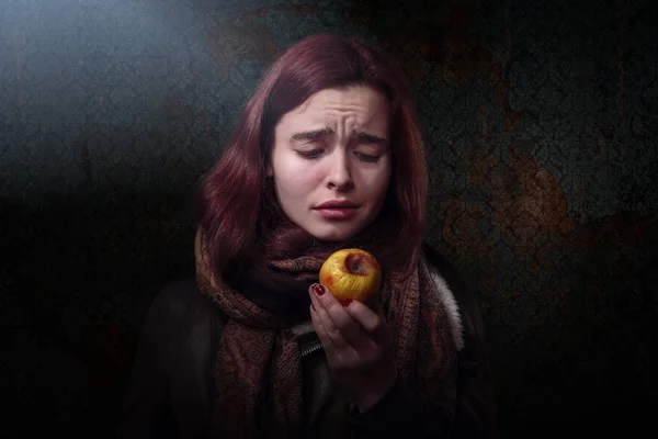 Hungry woman looking on a rotten apple — Stock Photo, Image