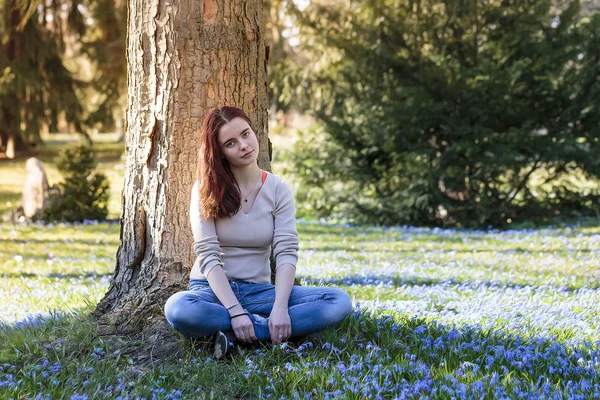 Mujer joven soñadora sentada en un prado de flores — Foto de Stock