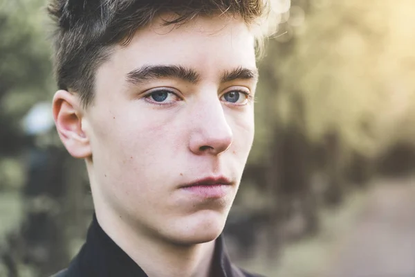 Närbild porträtt av en ung man i en park — Stockfoto