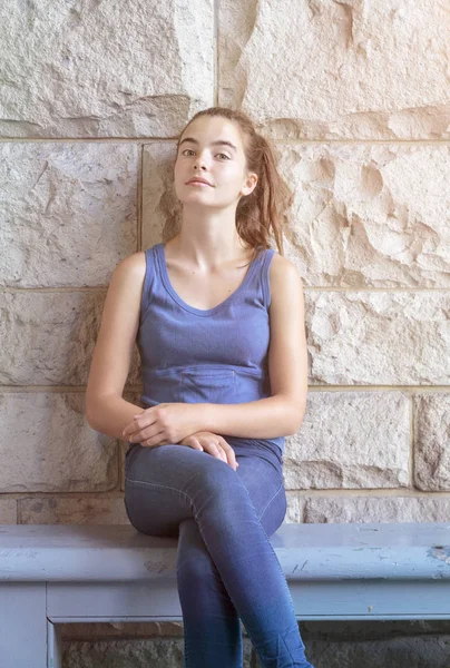 Portrait d'une jeune femme souriante assise sur un banc — Photo